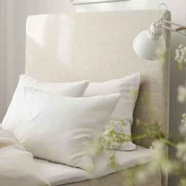 Weiße Himla Leinenkissen auf hellem Polsterkopfteil, minimalistisch und ruhig